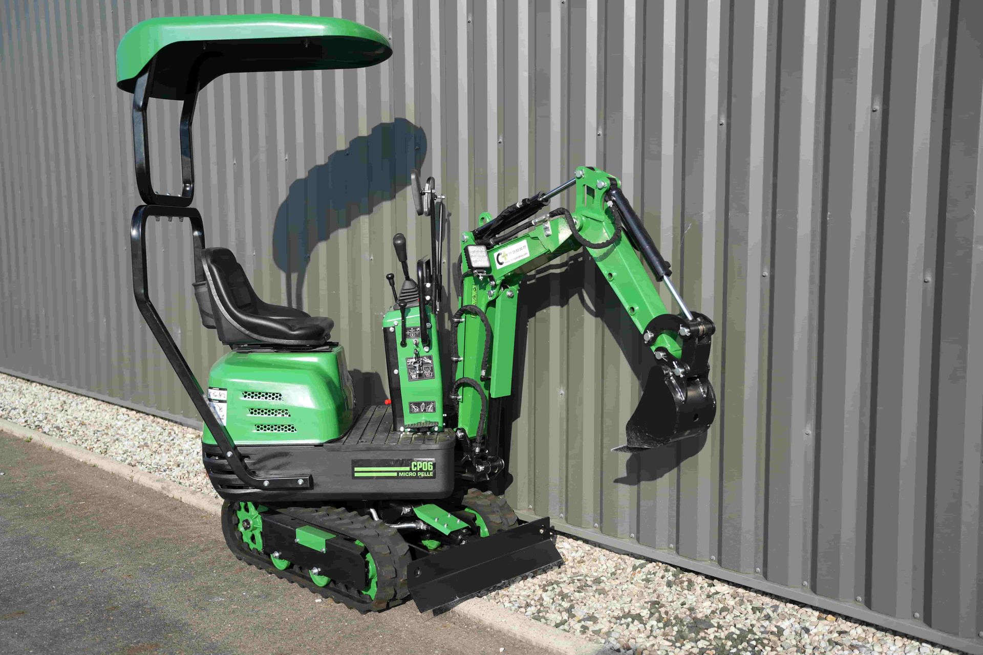 photo illustrant une mini-pelle CP06 avec son déport de flèche de chez Chargeur Plus sur un fond gris