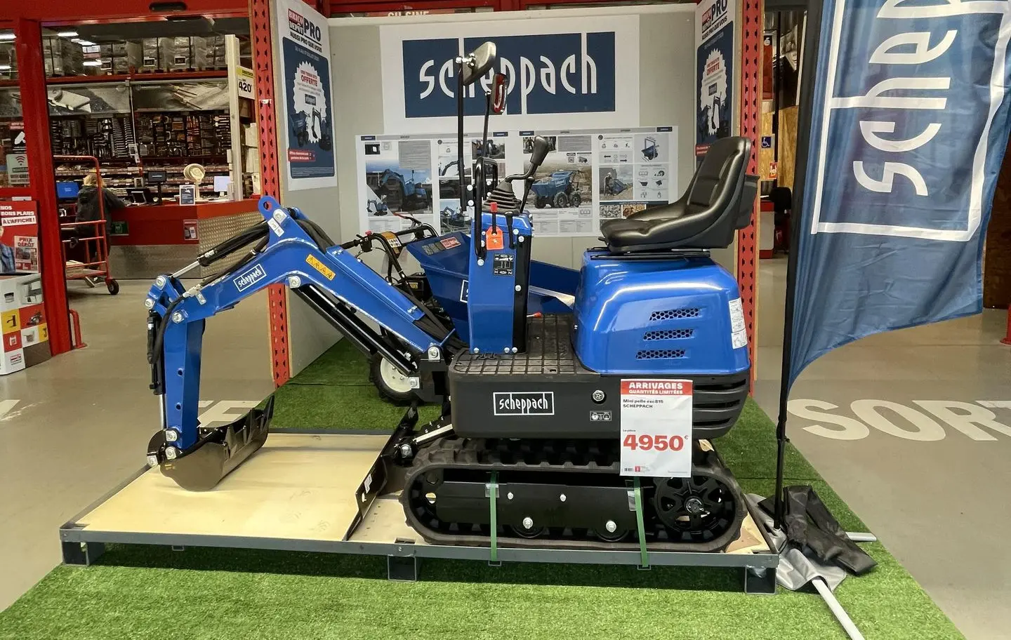 photo illustrant une mini-pelle scheppach dans un brico dépôt elle est bleue et on apperçoit le prix de 4950€