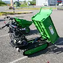Mini dumper à chenilles vert avec benne hydraulique relevée, vu en diagonale sur un parking, modèle ChargeurPlus