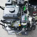 Vue de dessus du moteur et levier de vitesse d’un mini dumper à chenilles, avec indicateurs de vitesses et étiquettes de sécurité visibles