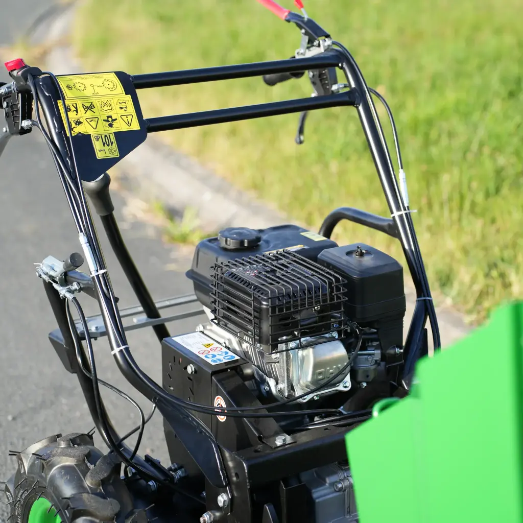 Vue rapprochée du moteur et du guidon d’un mini dumper motorisé, avec commandes manuelles et pictogrammes de sécurité visibles