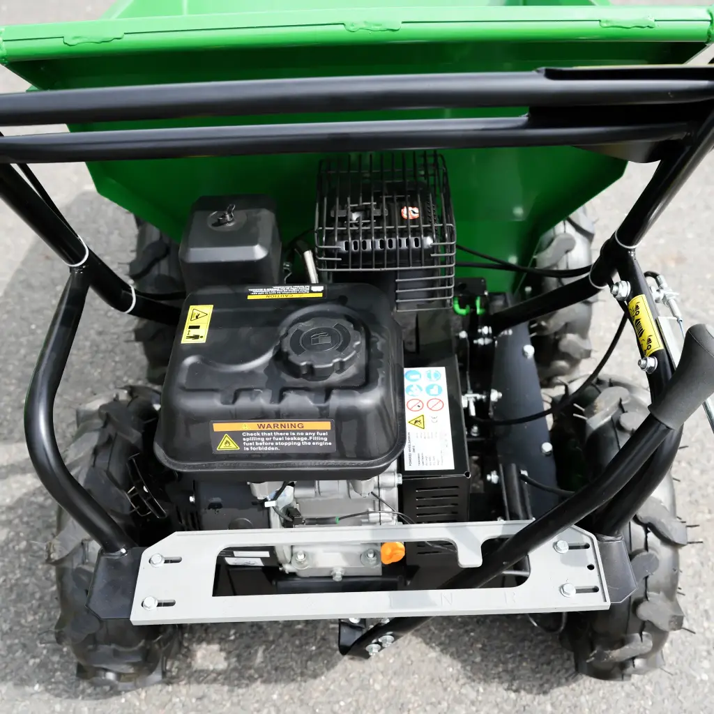 Vue de dessus du moteur et du châssis d’un mini dumper motorisé, avec commandes de marche avant et arrière, réservoir d’essence et roues tout-terrain
