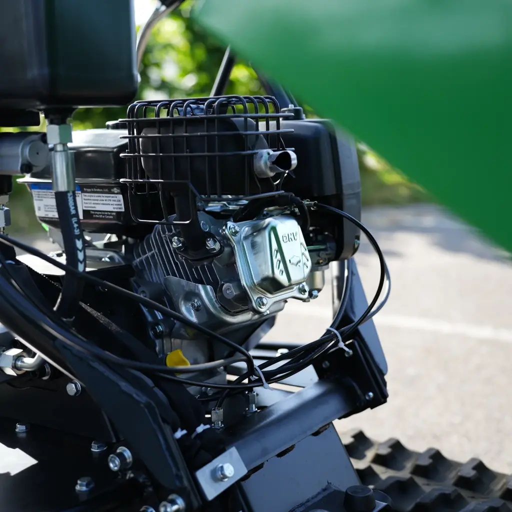 Vue détaillée du moteur thermique du dumper Chargeur Plus, avec échappement protégé, câblage et fixations visibles sur le châssis à chenilles