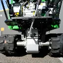 Vue avant du dessous d'un dumper Chargeur Plus, avec boîte de transmission, levier de commande et roues motrices visibles