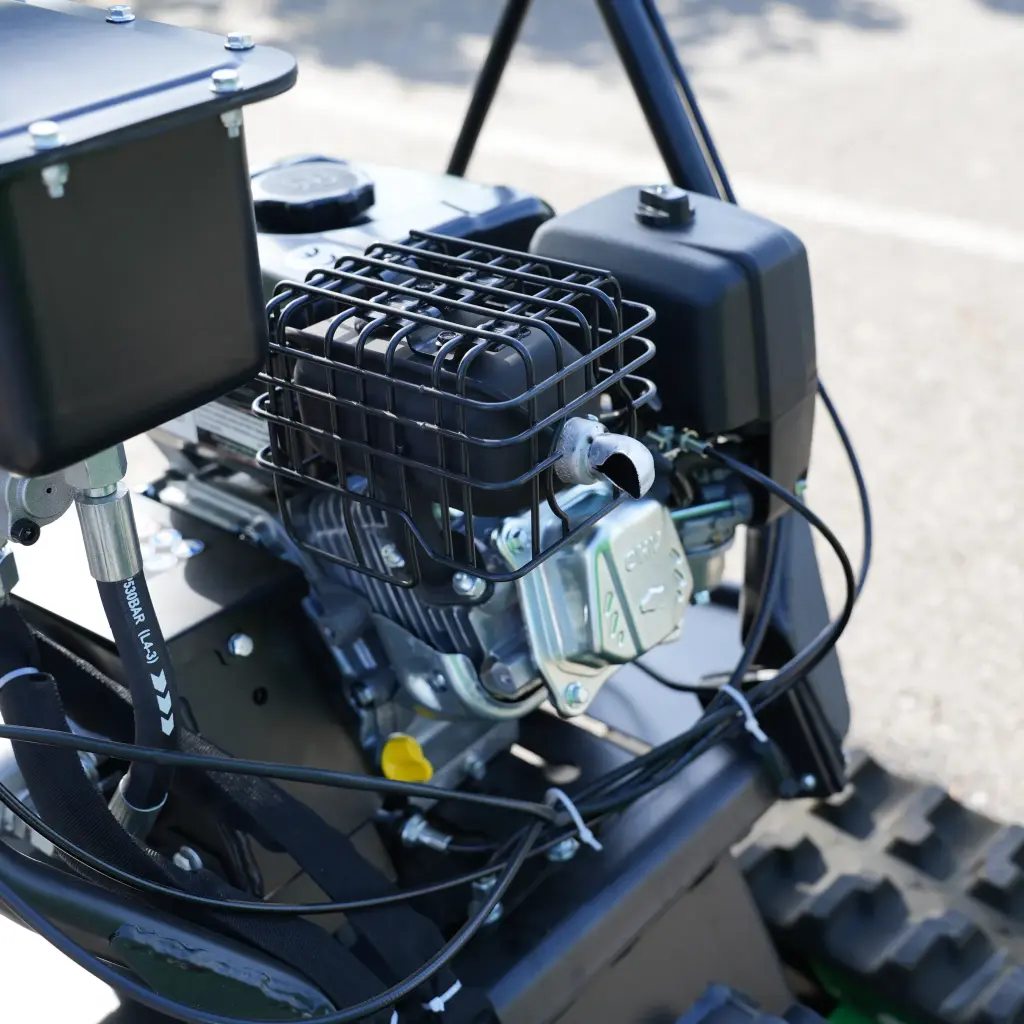 Gros plan sur le moteur thermique du dumper Chargeur Plus, avec échappement protégé par une grille, réservoirs et câblage visibles