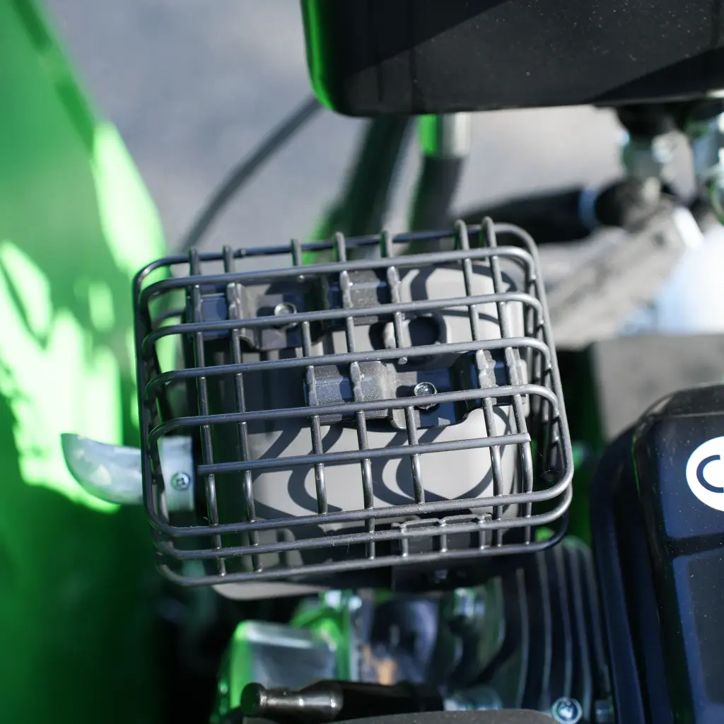 Vue rapprochée du moteur d’un dumper Chargeur Plus, avec protection grillagée entourant le système d’échappement