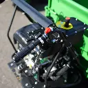 Poignée de commande du dumper Chargeur Plus avec interrupteur rouge ON/OFF, levier d’accélérateur et tableau de réglage en arrière-plan