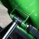 Gros plan sur le système d’articulation hydraulique et la fixation de la benne d’un dumper Chargeur Plus, avec vérin et axe métallique