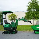 photo de profil d'une minipelle CP06 de 685kg avec le bras semi ouvert versant dans un dumper