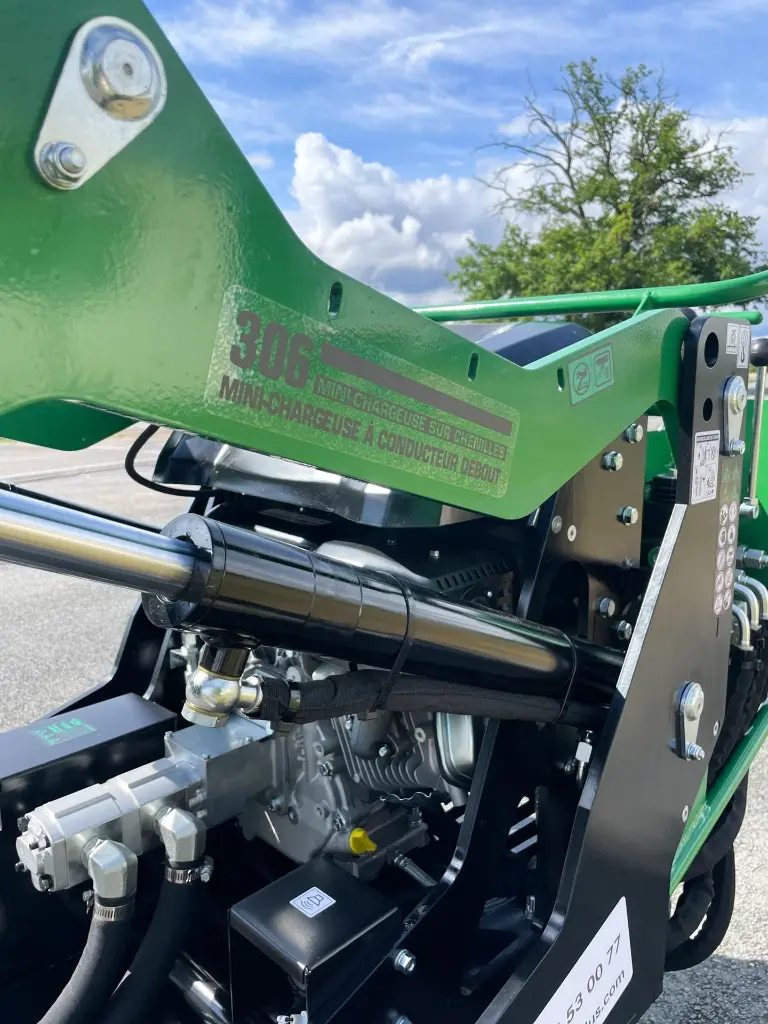 plan rapproché sur la mini chargeuse mc306 de chez chargeur plus et son verin permettant d'activer le bras.webp