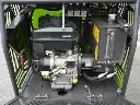 Compartiment moteur d’un dumper vert avec moteur thermique, réservoir hydraulique gradué, lanceur à rappel et composants mécaniques visibles.