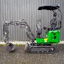 Chargeurplus: Vue latérale complète de la mini-pelle compacte sur chenilles, dotée d’un bras hydraulique articulé avec godet de terrassement, d’une lame de nivellement avant et d’un poste de conduite ouvert avec toit de protection.