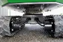 Chargeurplus: Vue détaillée du train de roulement sur chenilles, mettant en valeur les moteurs hydrauliques, les raccordements renforcés et la structure robuste assurant stabilité et mobilité sur tous types de terrains.