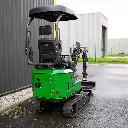 Chargeurplus vous présente la même mini-pelle verte sur chenilles, cette fois photographiée de trois quarts arrière gauche, révélant le dossier du siège opérateur, la structure du ROPS et la partie arrière de la carrosserie verte avec le bras hydraulique replié visible sur le côté droit.