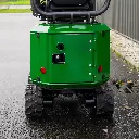 Chargeurplus vous présente un gros plan sur la partie arrière de la mini-pelle CP09, mettant en évidence la carrosserie verte avec sa trappe d'accès verrouillable, ses deux feux rouges, la prise de recharge et les chenilles en caoutchouc.