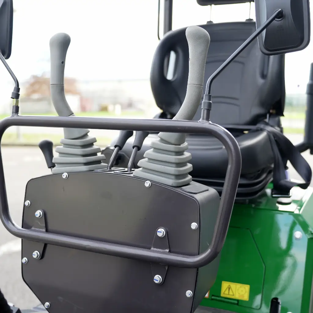 Chargeurplus: Vue rapprochée du poste de conduite avec siège ergonomique, doubles commandes hydrauliques et leviers de pilotage offrant un contrôle précis de la mini-pelle.