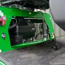 Chargeurplus vous présente un gros plan sur le compartiment moteur ouvert de la CP09, révélant le groupe motopropulseur thermique avec son filtre à air, le vérin hydraulique et le bouton d'arrêt d'urgence rouge visible sur la gauche.