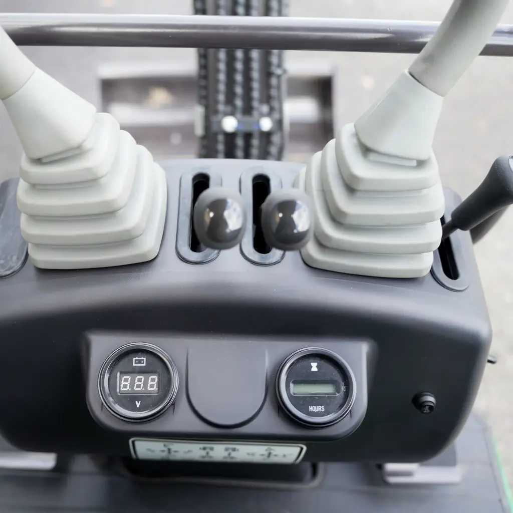 Chargeurplus: Gros plan sur les commandes de pilotage avec joysticks hydrauliques, leviers de contrôle et tableau de bord intégré pour une utilisation précise et intuitive.