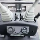 Chargeurplus: Gros plan sur les commandes de pilotage avec joysticks hydrauliques, leviers de contrôle et tableau de bord intégré pour une utilisation précise et intuitive.