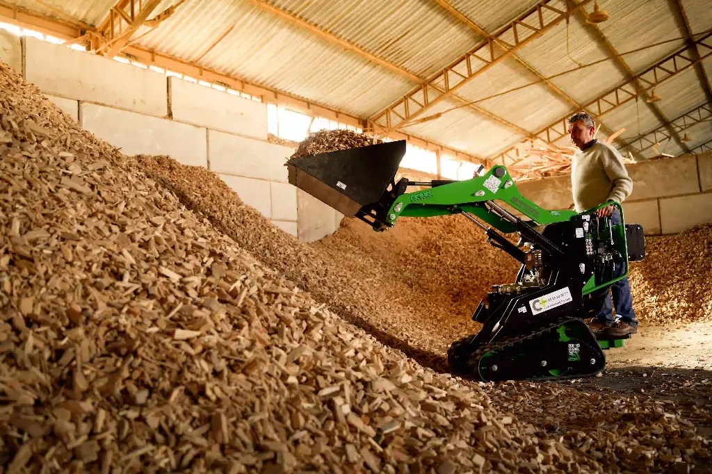 ChargeurPlus : mini-chargeur sur chenilles en pleine action, équipé d’un godet de grande capacité pour charger, déplacer et manutentionner efficacement des matériaux en vrac dans les environnements industriels et agricoles.