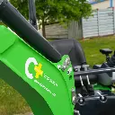 gros plan sur le logo chargeur plus présent sur le bras d'une mini-pelle chargeur plus on aperçoit en arrière plan le pupitre de la mini pelle et le terrain