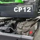 photo zoomé des chenilles de la mini-pelle de la gamme CP12 écrit en gros en blanc. Système de transmission visible