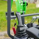 photo zoomé sur le pommeau de vitesse de la mini-pelle. Vérin inversé et godet visible.