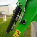 photo zoomé sur le vérin de la mini-pelle CP12 et sur les raccords hydrauliques.