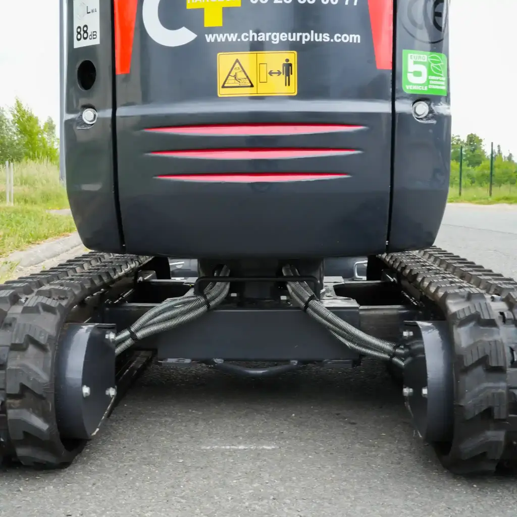 zoom sur les chenilles vues de dos. Chenilles étendues à leur largeur maximale, notice de sécurité visible.