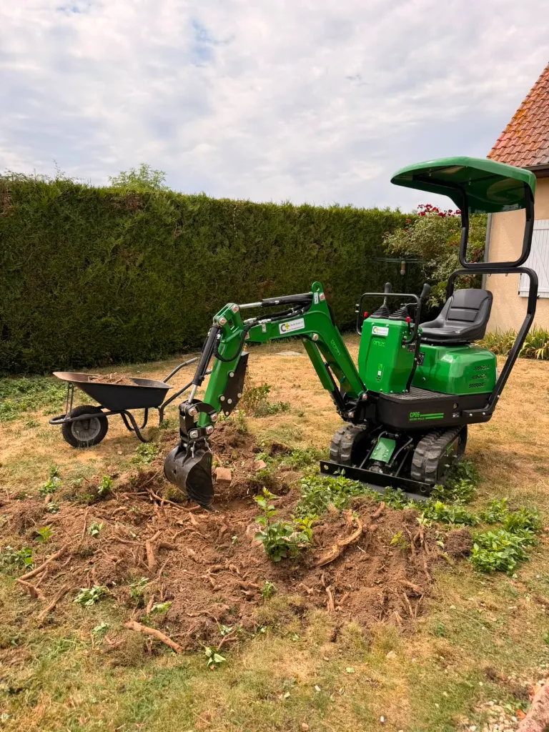 CP06 Chargeur Plus est en pleine opération de dessouchage, creusant autour d'une souche pour dégager efficacement les racines.