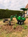CP06 Chargeur Plus est en pleine opération de dessouchage, creusant autour d'une souche pour dégager efficacement les racines.