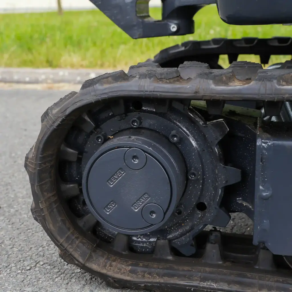 photo de côté des chenilles de la mini-pelle avec zoom sur les roues crampés