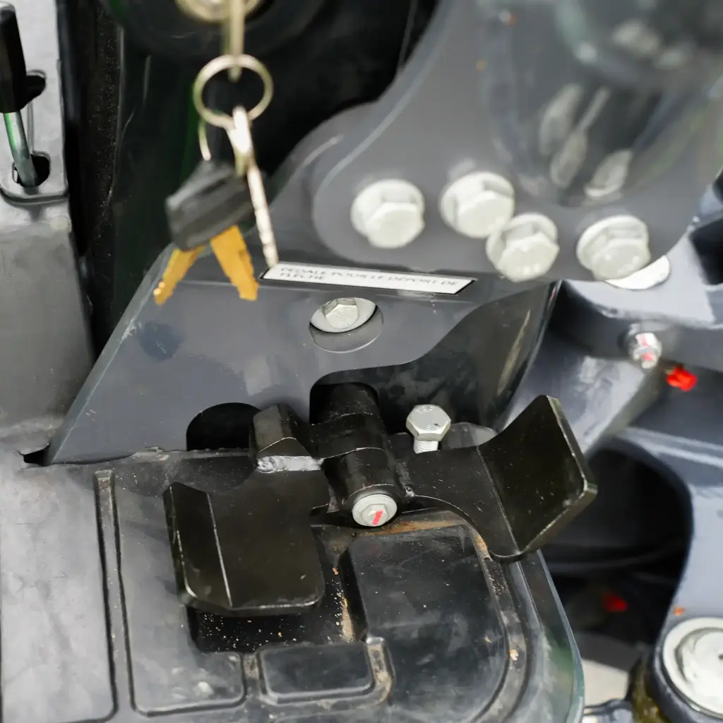 zoom sur la pédale du déport de flèche et de la lame et clés de la mini-pelle visible