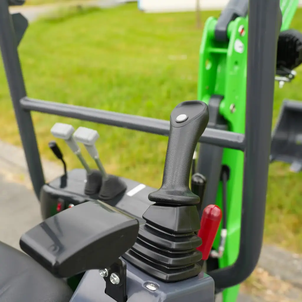 photo des commandes de contrôle de la mini-pelle avec pommeau de vitesse visible.